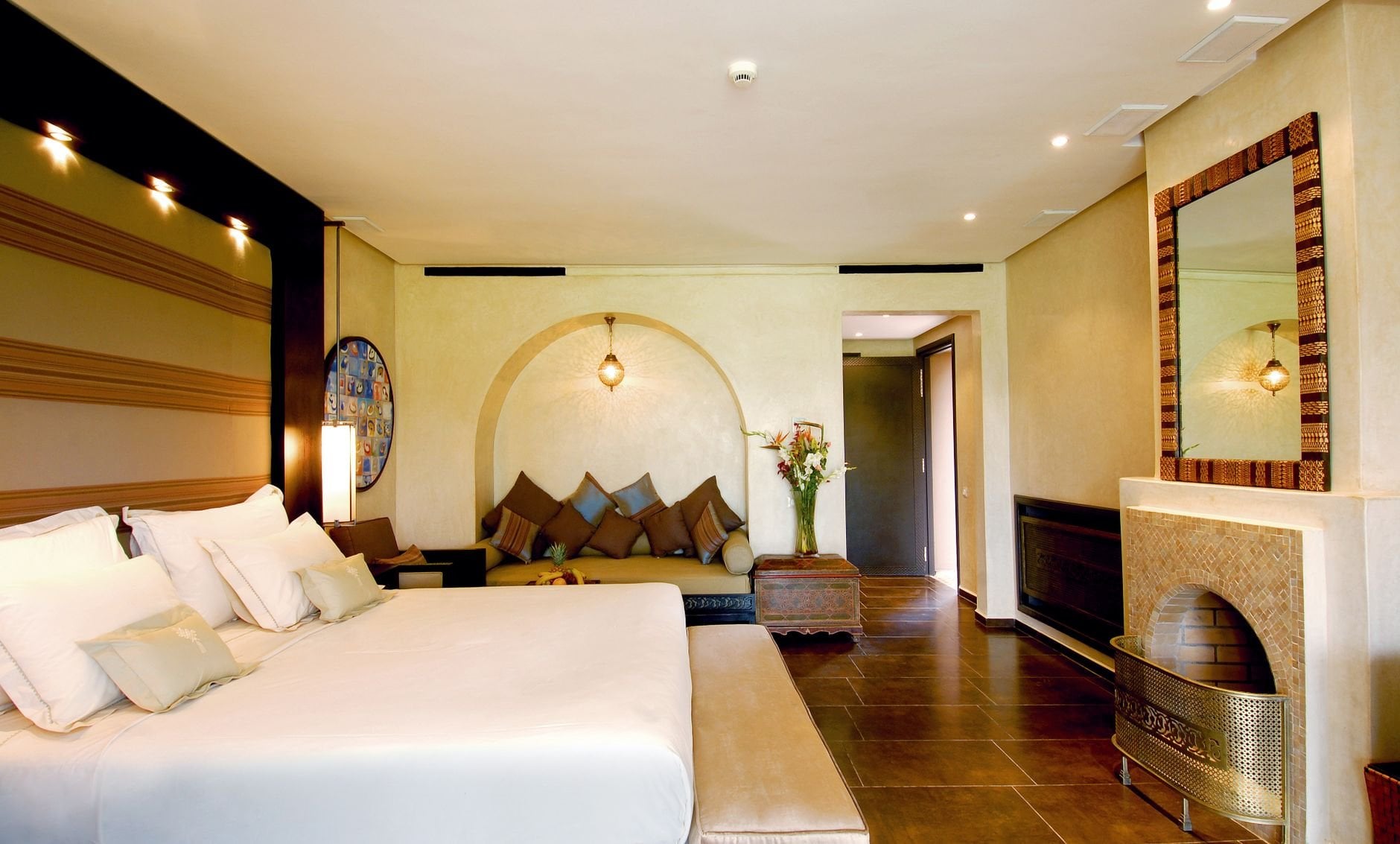 Elegant hotel room featuring a spacious bed, stylish decor, and warm lighting.